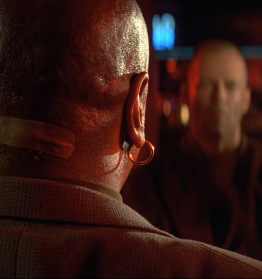 Captura-de-pantalla_3-1-2026_94922_www.youtube.com-fotor-2026010310048 Análisis de fotograma en Pulp Fiction: cuando el poder da la espalda y la traición espera al fondo